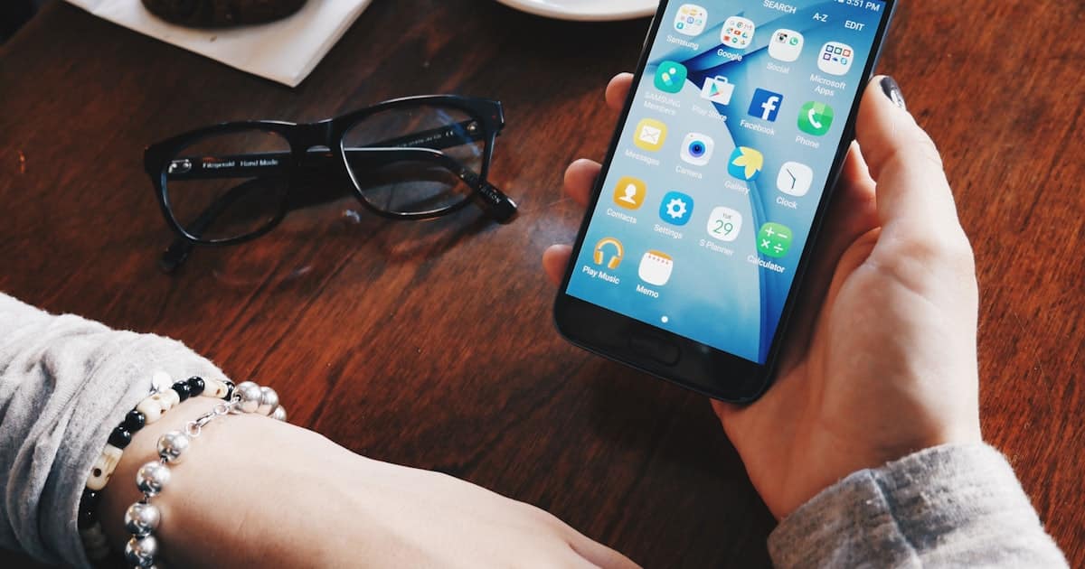 Telefon w dloni podczas obslugi bankowosci mobilnej